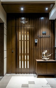 an entry way with wood paneling and decorative artwork on the wall, along with a checkered tile floor