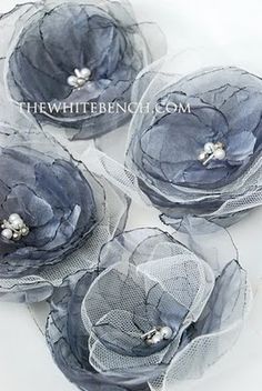 four blue flowers are sitting in clear plastic bags