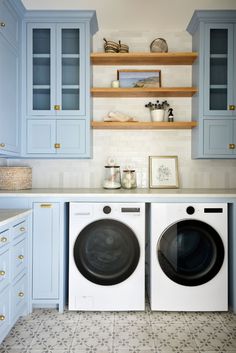 a washer and dryer in a small room with blue cabinets on the wall