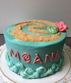 there is a blue cake that has the word moan on it and sand in the shape of a spiral