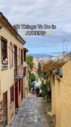 an alley way with buildings and graffiti on the walls, along with words that read 12 things to do in athens