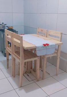 a wooden table and two chairs in a room with tile flooring on the walls