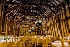 the inside of a barn with tables and chairs set up for a formal function or wedding