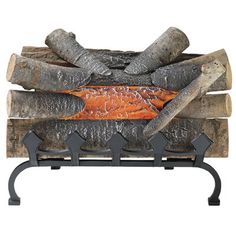 a fish is cooking on a grill with logs and tongs in front of it