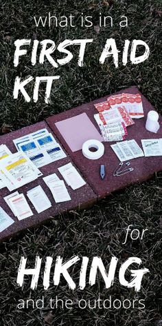 the first aid kit for hiking is laid out on the ground with paper, tape and scissors