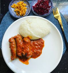 a white plate topped with meat and mashed potatoes