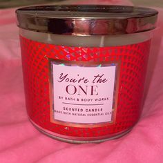 a candle that is on top of a pink blanket with the words you're the one