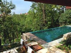 an image of a pool surrounded by trees and chairs with the caption that reads, i'm not sure what this is