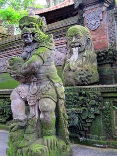 two stone statues sitting next to each other