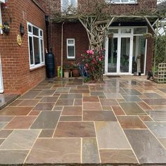 an outdoor patio with stone pavers and brick walls