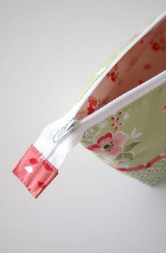 an open zippered pouch sitting on top of a white table next to a wall