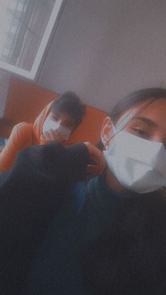 two people wearing face masks in a room