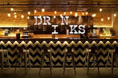 a bar with stools in front of it that says drink n'inks