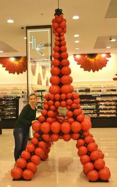 the eiffel tower made out of tomatoes is displayed in a grocery store with a woman standing next to it