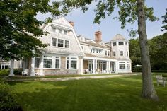 a large white house sitting on top of a lush green field