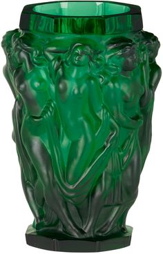 a green glass vase sitting on top of a table