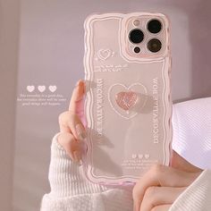 a person holding up a phone case with a heart on it and a ring in their hand