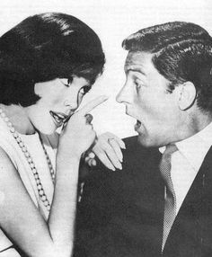 an old black and white photo of two people talking to each other with their mouths open