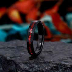 a black ring with red lights on it sitting on top of a rock