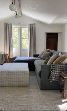 a living room filled with furniture next to a window and a rug on the floor