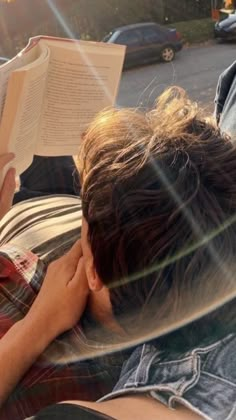 a person laying on the ground reading a book