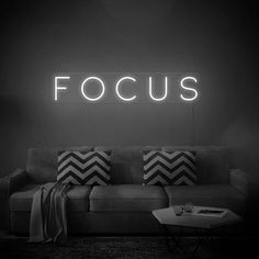 a black and white photo of a couch with the word focus lit up above it