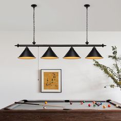 a pool table with three lights hanging over it