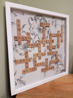 scrabble tiles are arranged in the shape of flowers on a white framed wall