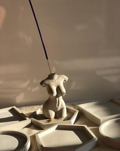 a white sculpture sitting on top of a table next to plates