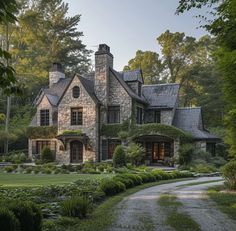 a large stone house surrounded by lush green trees