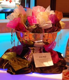 a large metal bowl filled with lots of colorful flowers on top of a white table