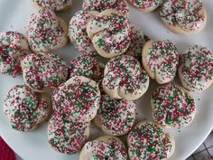 a white plate topped with sugar cookies covered in sprinkles on top of a table