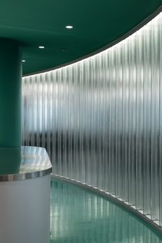 the curved wall is made up of metal bars and glass panels, along with a circular counter