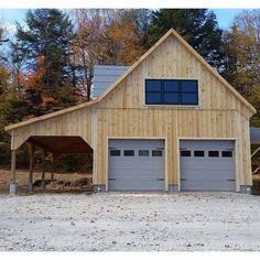 a two car garage in front of a wooded area