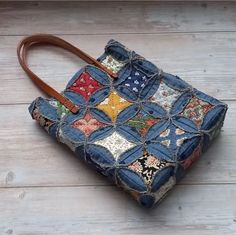 a handbag made out of old jeans on a wooden floor with a leather handle