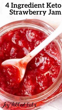 strawberry jam in a glass jar with a white spoon and text overlay reading 4 ingredient keto strawberry jam