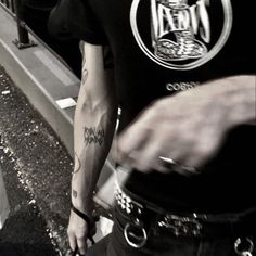 a man with tattoos on his arm walking down the street