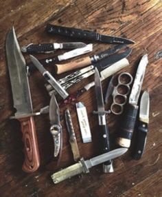 an assortment of knives on a wooden table