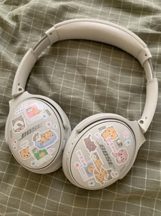 the headphones have stickers on them and are laying on top of a bed