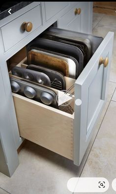 an open drawer in the middle of a kitchen