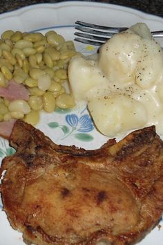 a white plate topped with meat and beans