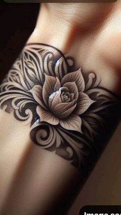 a black and white flower tattoo on the side of a woman's left arm