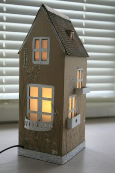 a paper house that is lit up with the light coming from it's windows