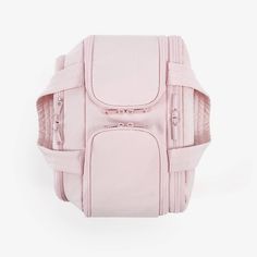 a pink purse with zippers on the front and straps around the bottom, sitting against a white background