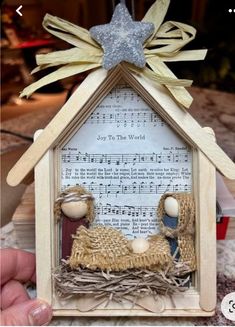 a nativity scene made out of wood with music sheets and stars on the top