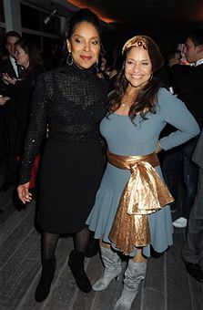 two women standing next to each other at a party