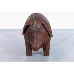 a wooden pig statue sitting on top of a cement floor