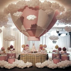 a hot air balloon birthday party with pink, white and gold balloons on the ceiling