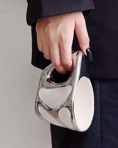 a woman's hand holding a silver purse