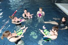 a group of people in a swimming pool giving the thumbs up sign to each other